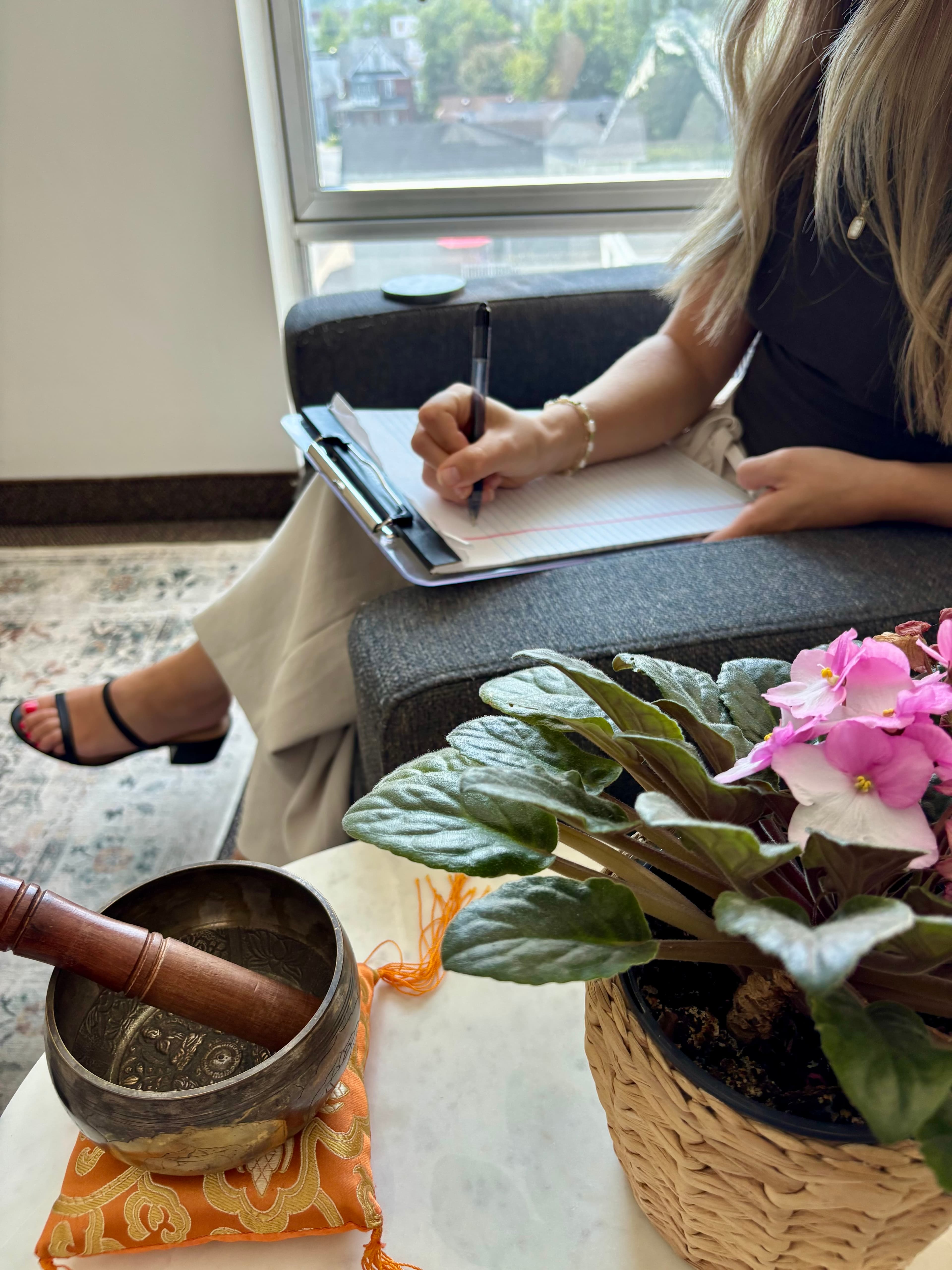 Une psychologue prend des notes, assise dans un bureau de la clinique.